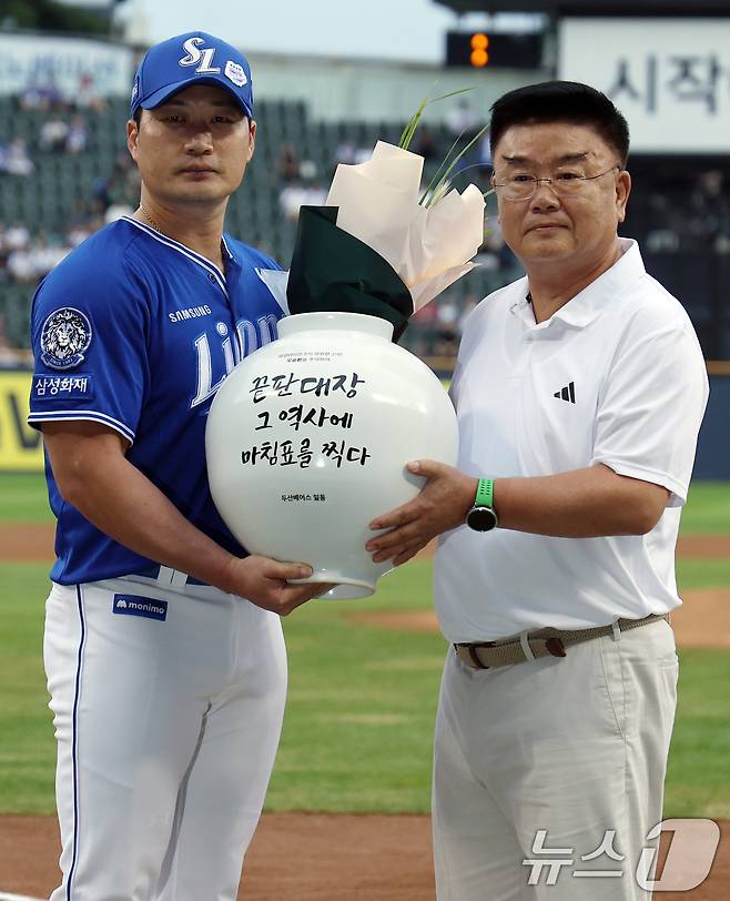 삼성 오승환이 28일 오후 서울 송파구 잠실야구장에서 열린 은퇴투어 기념 행사에서 김태룡 두산 베어스 단장에게 항아리를 전달 받고 있다. 2025.8.28/뉴스1 ⓒ News1 박정호 기자