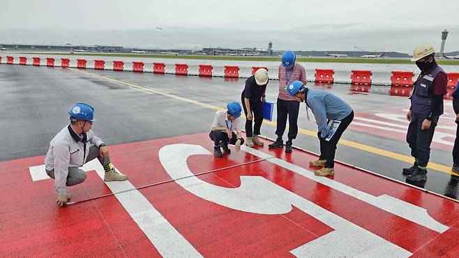 인천국제공항공사 직원들이 제2활주로 포장면에 도색된 표지 규격을 점검하고 있다. 활주로 표지는 항공기 조종사가 위치와 방향, 이동 구역을 인식할 수 있도록 국토교통부 공항·비행장 시설 설치 기준에 따라 체계적으로 관리된다. 인천공항공사 제공