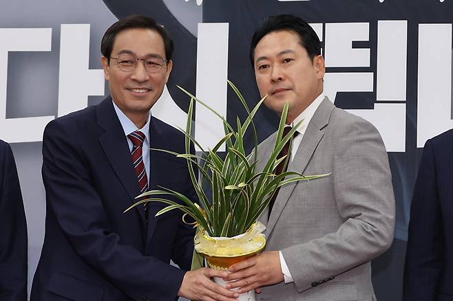 우상호 대통령실 정무수석이 27일 서울 여의도 국회에서 국민의힘 장동혁 신임 대표를 예방해 이재명 대통령이 보낸 축하난을 전달하고 있다. 2025.8.27 [사진=연합뉴스]