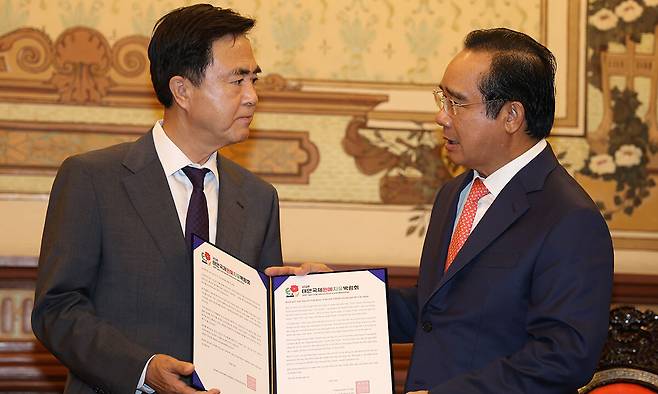 김태흠(왼쪽)충남지사가 호치민시청에서 응우옌 반 득 호치민시 인민위원장에게 내년 4월 개최하는 태안국제원예치유박람회 초청장을 건넸다. 충남도 제공