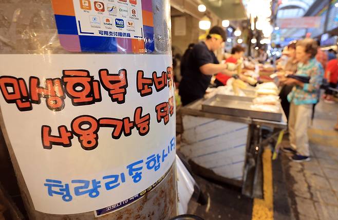 29일 오후 서울 시내 한 전통시장에 '민생 회복 소비 쿠폰을 사용할 수 있다'는 안내문이 붙어 있다. /뉴스1