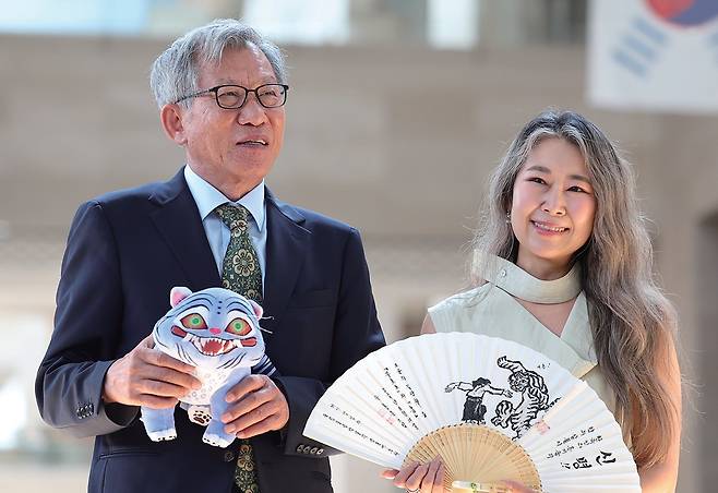 넷플릭스 애니메이션 ‘케이팝 데몬 헌터스’의 매기 강 감독과 유홍준(왼쪽) 국립중앙박물관 관장이 8월 21일 서울 용산구 국립중앙박물관에서 선물을 주고받은 뒤 기념 촬영을 하고 있다. /연합뉴스