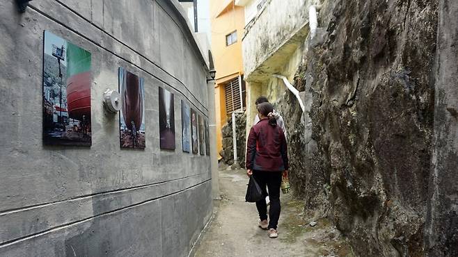 부산 영도구 봉래동 골목길에서 전시하고 있는 ‘내 기억 속 초상, 삶을 잇는 골목 사진전’ 모습. 비주류사진관 제공