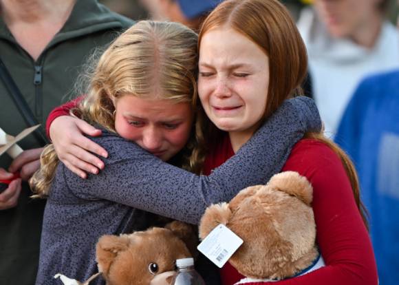 지난 27일(현지시간) 미국 미네소타주 미니애폴리스 가톨릭학교에서 총기난사 사건이 발생한 가운데 인근 공원에서 열린 촛불 추모식에서 두 어린이가 서로 껴안고 위로하며 울음을 터뜨리고 있다. [사진=로이터/연합뉴스]