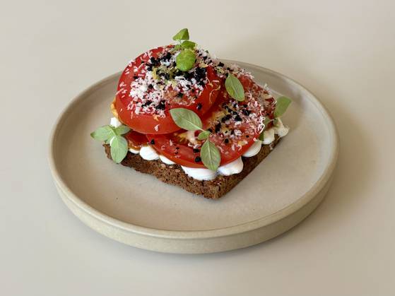 Smorrebrod, Danish open-faced sandwich, with whipped ricotta and tomato jam, topped with fresh tomato slices, cheese shavings and dry black olive bits at Danish eatery Mitbord [LEE JIAN]