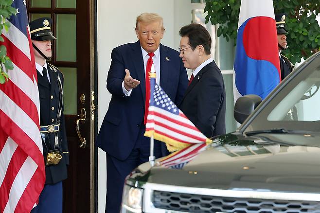 Korean President Lee Jae Myung, right, waves as he is greeted by U.S. President Donald Trump ahead of their first bilateral summit at the White House in Washington on Aug. 25. [JOINT PRESS CORPS]