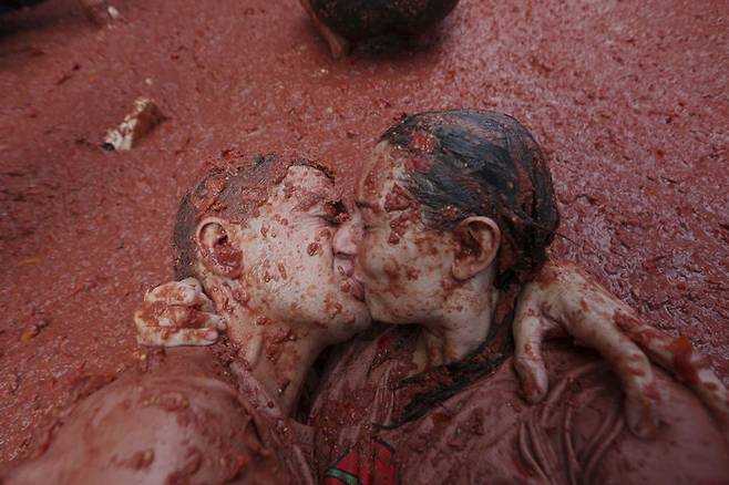 [부뇰=AP/뉴시스] 지난 27일(현지 시간) 스페인 발렌시아 인근 부뇰 마을에서 열린 연례 '라 토마티나' 축제에서 한 커플이 토마토 범벅이 된 채 입 맞추고 있다. 이 축제는 매년 8월 마지막 수요일에 열리며 1945년경, 마을 축제 도중 우연히 시작된 토마토 던지기에서 유래한 것으로 알려져 있다. 2025.08.29.