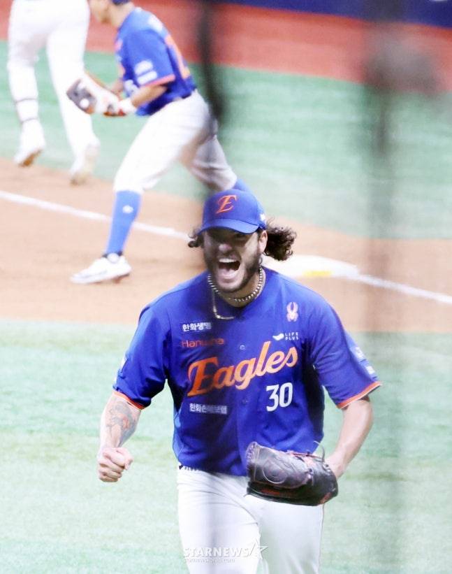 한화 선발투수 폰세가 28일 고척스카이돔에서 열린 2025KBO리그 한화이글스와 키움히어로즈의 경기 5회말 무사 만루위기에서 1실점으로 선방한 후 더그아웃으로 향하던 중 송성문을 만나 미소짓고 있다. /사진=강영조 선임기자