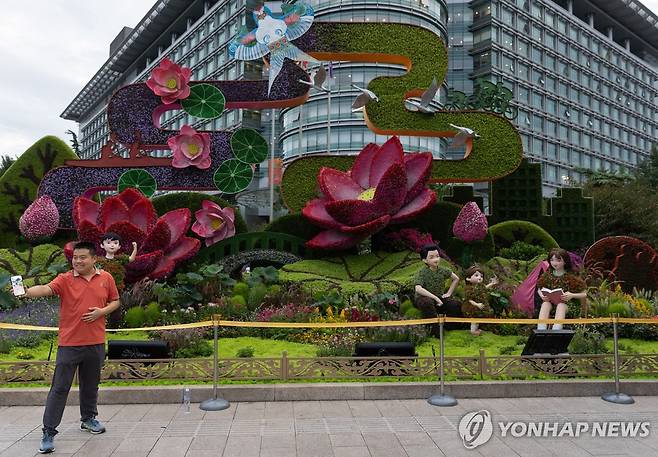 베이징 시내의 한 열병식 기념 화단 앞에서 사진찍는 시민 [EPA 연합뉴스 자료사진. 재판매 및 DB 금지]