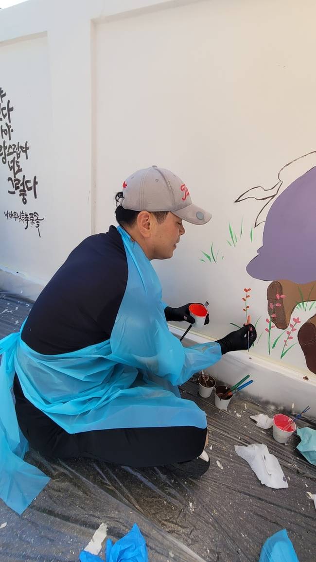 ▲ 윤종호 경북도의원이 구미여중 담장 벽화그리기에 동참해 벽화를 그리고있다.이봉한기자