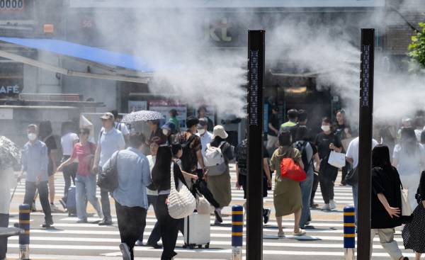 동구 부산역 앞 횡단보도에 선 시민과 관광객들이 쿨링포그를 맞고 있다. 국제신문DB