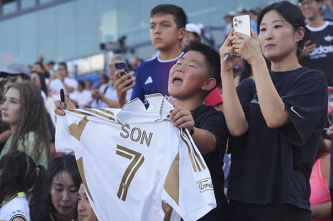 [프리스코=AP/뉴시스] 로스앤젤레스(LA) FC 손흥민의 한 소년 팬이 지난 23일(현지 시간) 미 텍사스주 프리스코 도요타 스타디움에서 열린 2025 메이저리그사커(MLS) FC 댈러스와 경기에 앞서 손흥민을 응원하고 있다. 손흥민은 전반 6분 프리킥으로 선제골을 넣어 MLS 데뷔골을 기록했다. 2025.08.24.