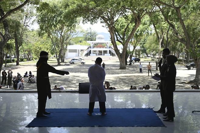 지난 26일(현지시간) 인도네시아 아체주 반다아체에서 태형 집행관이 공원 화장실에서 다른 남성과 키스해 샤리아(이슬람 율법)를 위반한 혐의로 유죄 판결을 받은 남성에게 등나무 지팡이로 매질을 하고 있다. 2025.8.26 AP 연합뉴스