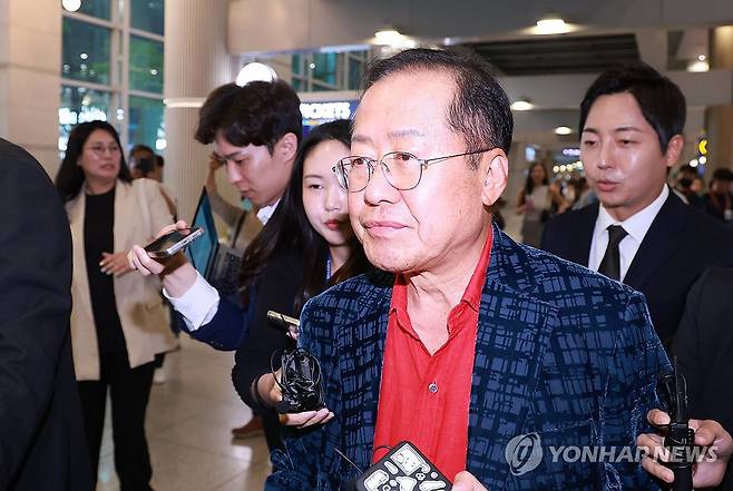 인터뷰 마치고 이동하는 홍준표 전 대구시장 (영종도=연합뉴스) 신현우 기자 = 홍준표 전 대구시장이 17일 인천국제공항 제1여객터미널을 통해 귀국, 취재진과 인터뷰를 마친 뒤 이동하고 있다. 홍 전 시장은 지난 4월 국민의힘 대선 후보 경선에서 패배한 뒤 탈당하고 미국 하와이에 머물렀다. 2025.6.17 nowwego@yna.co.kr
