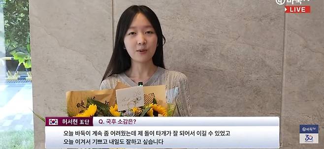 중국에서 인기가 많은 허서현 5단이 중국 바둑팬에게서 받은 꽃다발을 들고 인터뷰를 하고 있다.(사진 바둑TV 캡처)