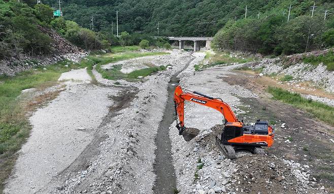 31일 강원 강릉시 주요 상수원인 오봉저수지 상류에서 한 관계자가 포크레인으로 물길을 내고 있다. /뉴스1