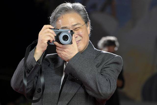 박찬욱 감독이 29일 이탈리아 베니스 리도섬의 살라 그란데에서 열린 제82회 베니스국제영화제 '어쩔수가없다' 공식 상영회를 앞두고 레드 카펫에서 카메라를 들고 사진을 찍는 포즈를 하고 있다. 베니스=EPA 연합뉴스