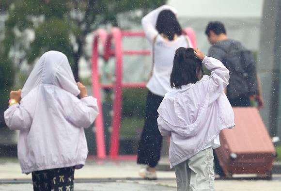 소나기가 내린 25일 오전 서울 종로구 광화문광장에서 아이들이 비를 피하기 위해 뛰고 있다. 2025.8.25  [사진=연합뉴스]