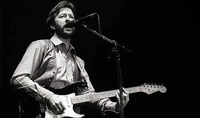 에릭 클랩튼의 노래는 감정을 밀어붙이는 대신, ‘숨’과 ‘쉼’을 제자리에 놓는 일에서 시작된다. 고음을 세우지 않고, 떨림으로 호소하지도 않은 채, 한 음이 지나가면 다음 음이 서둘지 않고 들어오며 그 틈에는 여백과도 같은 공기가 깔린다. 이 공기 속에서 듣는 이는 자신의 시간을 꺼내어 올려놓고 보게 되고, 스스로의 감정을 떠올리고, 곱씹고, 그의 감정과 닮은 모양을 찾아내는 경험을 한다. [게티이미지/Photo by Rob Verhorst]