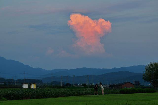 무더웠던 대지에 어둠이 내리자, 핑크빛 하트 모양의 구름이 하늘에 만들어지고 있다.