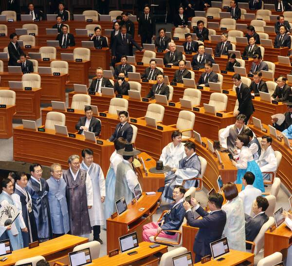 1일 여의도 국회에서 열린 정기국회 개회식에 앞서 한복을 입은 여당 의원들이 기념 촬영을 진행하는 반면 야당 의원들은 상복을 입은 채 앉아 있는 모습. 연합뉴스
