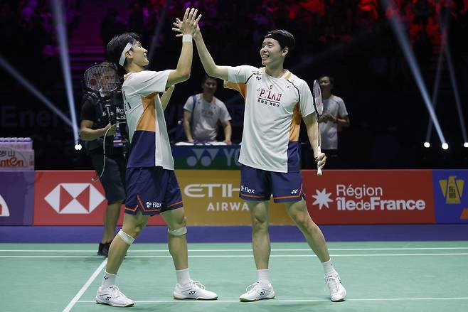 배드민턴 남자복식 세계 1위 김원호-서승재가 세계개인배드민턴선수권에서 우승한 뒤 손을 맞잡으며 기뻐하고 있다.   [EPA]