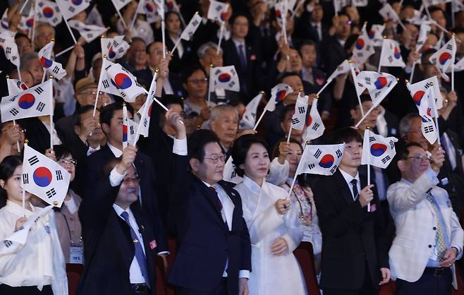 이재명 대통령과 정부 요인들이 지난 15일 서울 세종문화회관에서 80주년 광복절 경축식에서 태극기를 흔들고 있다. [연합]