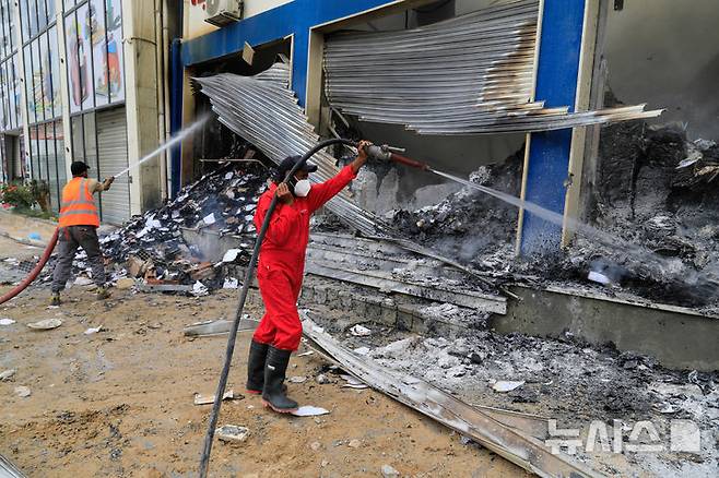 [트리폴리= AP/뉴시스] 리비아 서부 공단지역에서 8월 31일 대규모 폭발이 일어났다.  사진은 무장 군대들 간의 충돌로 지난 5월 14일 파괴된 리비아 수도 트리폴리 에서 소방대가 한 서점 화재의 잔불을 끄고 있는 광경.  2025. 09.01.