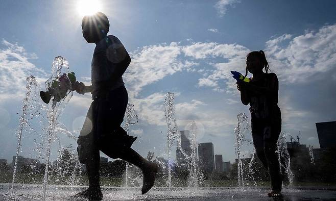 지난달 20일 일본 도쿄 한 공원에서 아이들이 분수대에서 물놀이를 하고 있다. AFP 연합뉴스