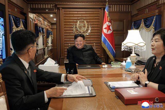 김정은 조선노동당 총비서 겸 국무위원장이 중국 베이징으로 가는 전용열차 안 집무실에서 당·정의 외교 책임자인 김성남 노동당 중앙위 국제부장(왼쪽), 최선희 외무상(오른쪽)과 웃는 얼굴로 회의를 하고 있다. 조선중앙통신 연합뉴스