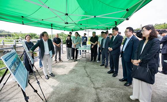 정헌율 시장과 국회 안호영 환노위원장이 왕궁 축산단지에서 자연환경복원사업에 대한 브리핑을 받고 있다. [사진=익산시 ]