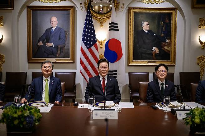 태극기와 성조기를 배경으로 나란히 앉은 조현 외교부 장관, 이재명 대통령, 김정관 산업통상자원부 장관.(왼쪽부터)  백악관