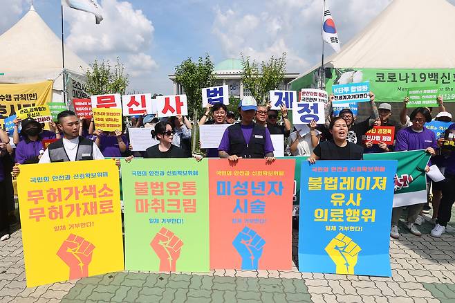A group of tattoo artists stage a protest calling for legislation of a bill that acknowledges tattooist as a legitimate occupation in front of the National Assembly in western Seoul on Aug. 27. [YONHAP]