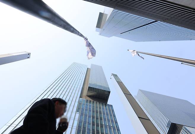 An office worker walks across a neighborhood in downtown Seoul where major companies' headquarters are located on March 24. [YONHAP]