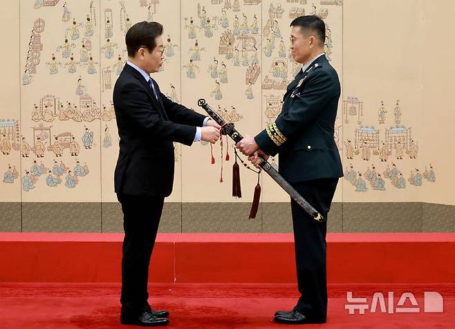 [서울=뉴시스] 최동준 기자 = 이재명 대통령이 2일 서울 용산 대통령실 청사에서 열린 대장 진급·보직 신고 및 삼정검 수치 수여식에서 김규하 육군참모총장의 삼정검에 수치를 달아주고 있다. (대통령실통신사진기자단) 2025.09.02. photocdj@newsis.com
