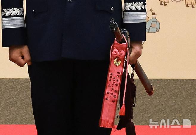 [서울=뉴시스] 최동준 기자 = 2일 서울 용산 대통령실 청사에서 열린 대장 진급·보직 신고 및 삼정검 수치 수여식에서 합동참모의장 후보자인 진영승 전략사령관이 삼정검을 들고 있다. (대통령실통신사진기자단) 2025.09.02. photocdj@newsis.com