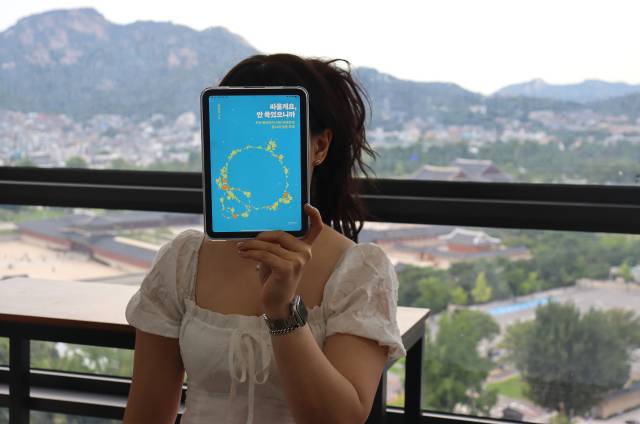 김진주씨가 저서 ‘싸울게요, 안 죽었으니까’ 표지를 들어 보이고 있다. 김수호 기자