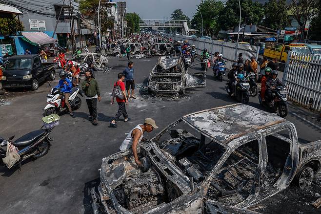 지난달 30일 인도네시아 자카르타 동자카르타 경찰 본부 밖에서 시위대에 의해 불이 난 경찰 차량의 일반적인 모습. 앞서 국회의원 주택 수당에 반대하는 시위 중 오토바이 운전자가 사망한 후 전국적으로 밤사이 시위 중 정부 건물과 경찰 차량에 불이 붙었다. /EPA 연합뉴스