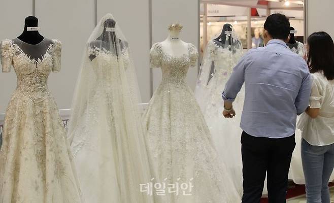 제54회 웨덱스코리아 웨딩박람회에서 예비 신랑 신부들이 웨딩드레스를 둘러보고 있다.ⓒ연합뉴스