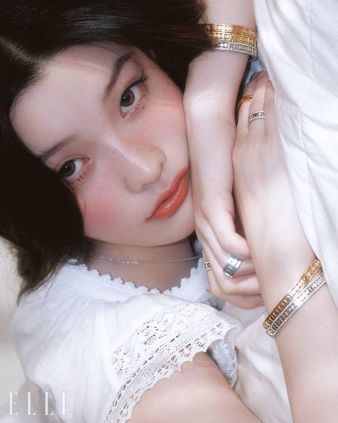 왼팔에 착용한 핑크골드, 옐로골드, 다이아몬드 세팅 화이트골드의 벨 에포크 릴 브레이슬릿, 검지에 낀 다이아몬드 세팅 핑크골드 5.7mm 벨 에포크 릴 링, 약지에 낀 화이트골드 8.3mm 벨 에포크 릴 링, 벨 에포크 릴 네크리스, 오른손 중지에 낀 핑크골드 5.7mm 벨 에포크 릴 링, 약지에 낀 화이트골드 5.7mm 벨 에포크 릴 링 오른팔에 착용한 핑크 골드, 다이아몬드 세팅의 화이트골드 벨 에포크 릴 브레이슬릿은 모두 Damiani. 드레스는 Viaplain.