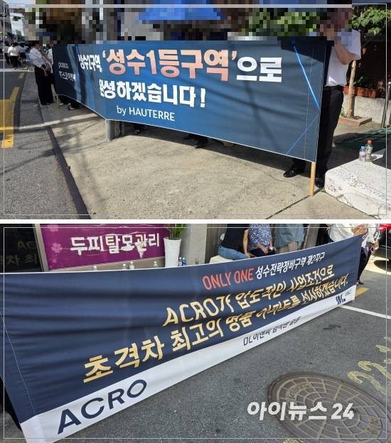 서울 성동구 성수2지구 대의원회를 앞두고 DL이앤씨와 포스코이앤씨 직원들이 현수막을 들고 있다. [사진=이수현 기자]