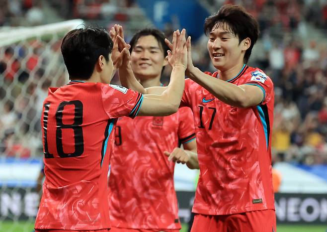 From left, Lee Kang-in, Oh Hyeon-gyu and Bae Jun-ho celebrate after scoring a goal against Kuwait in a 2026 FIFA World Cup qualifier on June 10. [NEWS1]