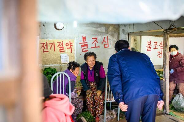 ▲ 장충남 남해군수가 시금치 묶음 작업장에 방문한 모습. 역시나 군수 보다는 주민들 표정을 중심에 뒀다. 사진=하철환 제공