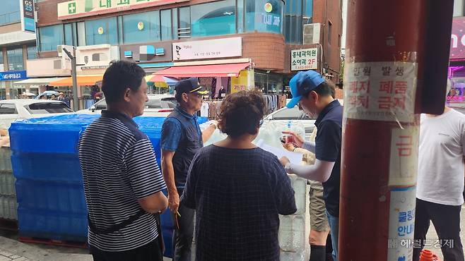 지난 2일 강릉 중앙시장 입구에서 상인들이 물을 배급받기 위해 모여있는 모습. 안효정 기자.