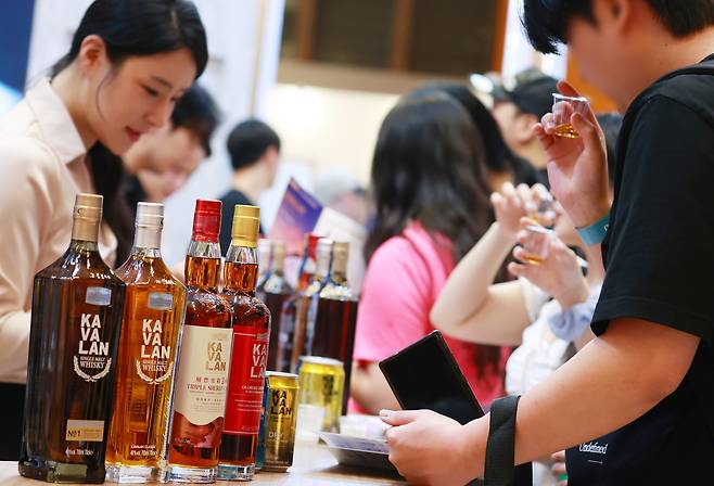 지난 27일 서울 강남구 코엑스에서 열린 2025 서울바앤스피릿쇼에서 관람객들이 다양한 주류를 시음하고 있다.[연합]
