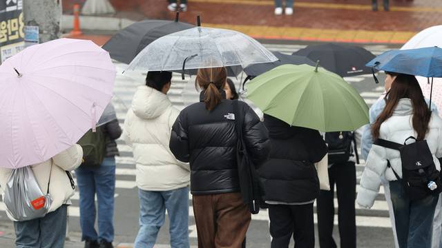▲ 대학교 학생들이 우산을 받쳐 들고 횡단보도를 건너고 있다.