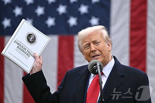 도널드 트럼프 미국 대통령이 2일(현지시간) 워싱턴 백악관 로즈가든에서 열린 ‘미국을 다시 부유하게’ 행사서 상호관세를 발표하며 최신 무역장벽 보고서를 들고 "오늘은 미국 역사에서 가장 중요한 날 중 하나인 미국 해방의 날＂이라고 말하고 있다. 2025.04.03 ⓒ AFP=뉴스1