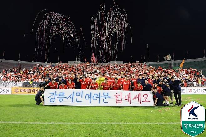 "강릉시민여러분 힘내세요" 플래카드를 걸고 단체사진을 찍은 강원 선수단(한국프로축구연맹 제공)