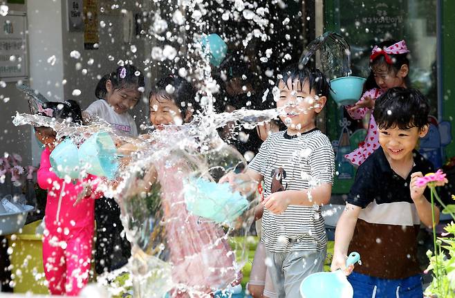 광주 북구청직장어린이집 앞마당에서 아이들이 교사와 물총놀이를 하며 더위를 식히고 있다./뉴스1