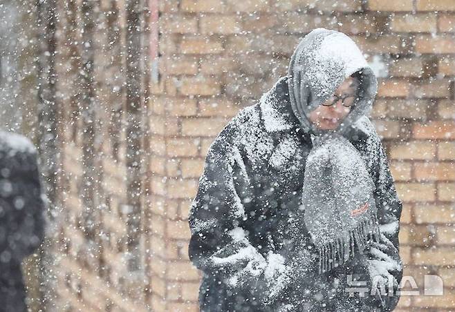 지난 2월 서울 중구 거리에서 시민들이 눈을 맞으며 이동하고 있다.ⓒ뉴시스